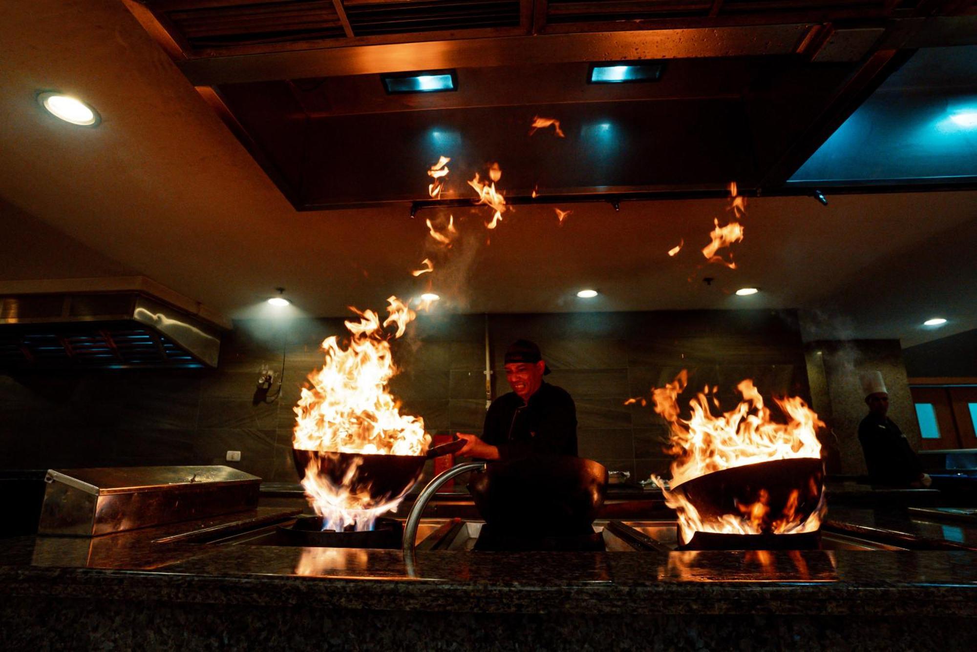The V Luxury Resort Sahl Hasheesh Hurghada Exterior photo A chef cooking with a wok