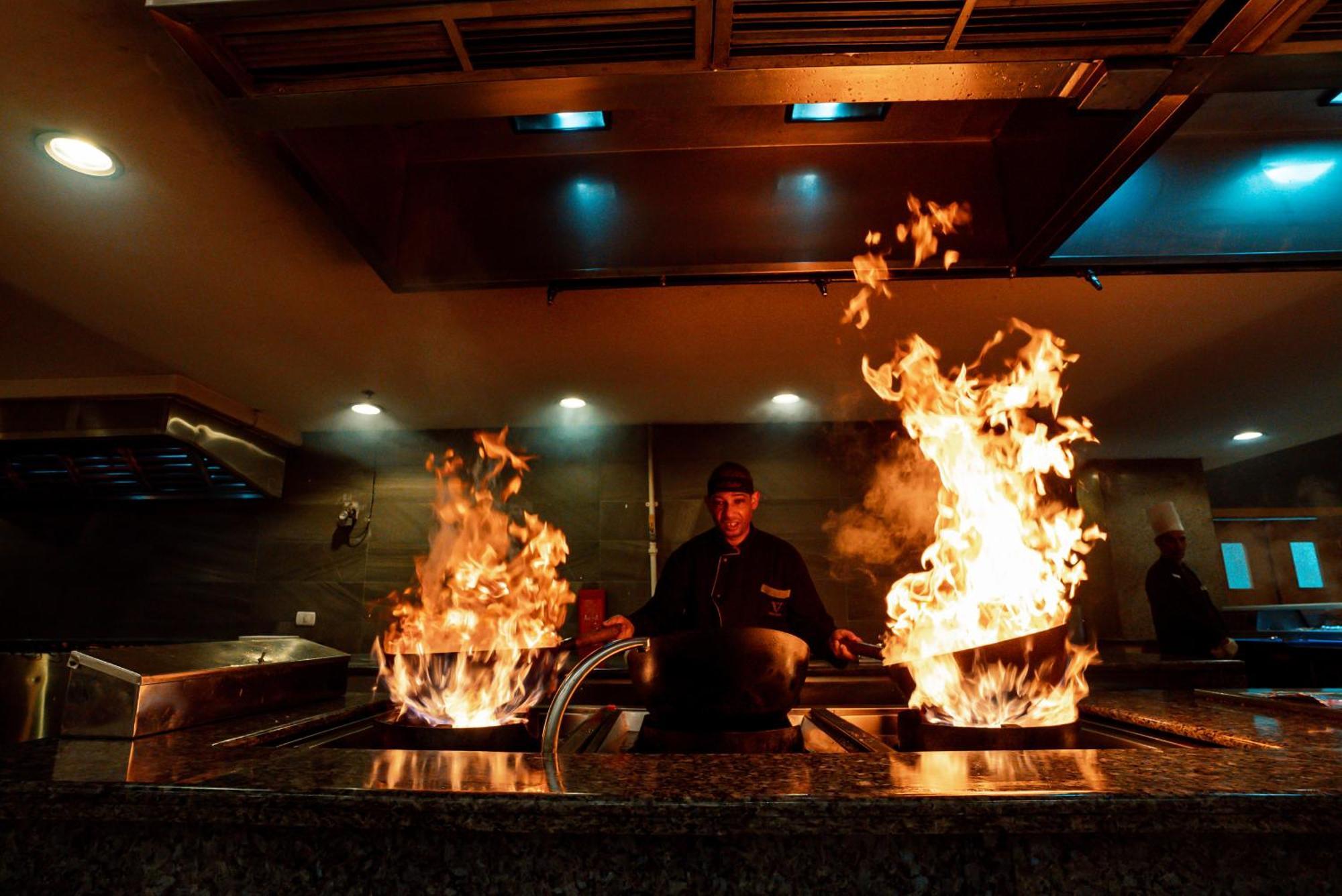 The V Luxury Resort Sahl Hasheesh Hurghada Exterior photo A chef cooking with a wok